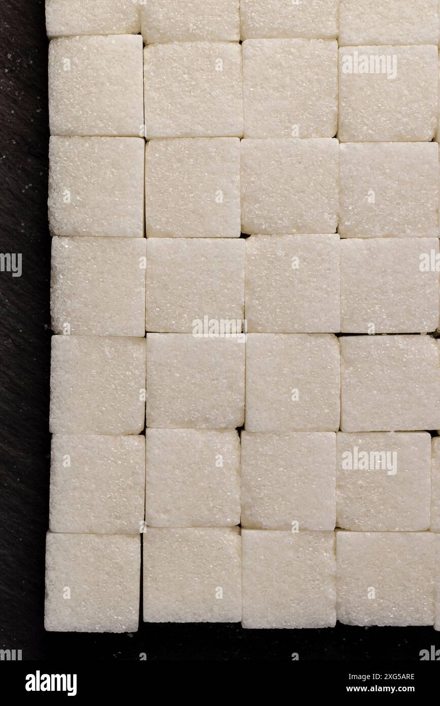 white square sugar on a black background , lump sugar in the shape of a ...