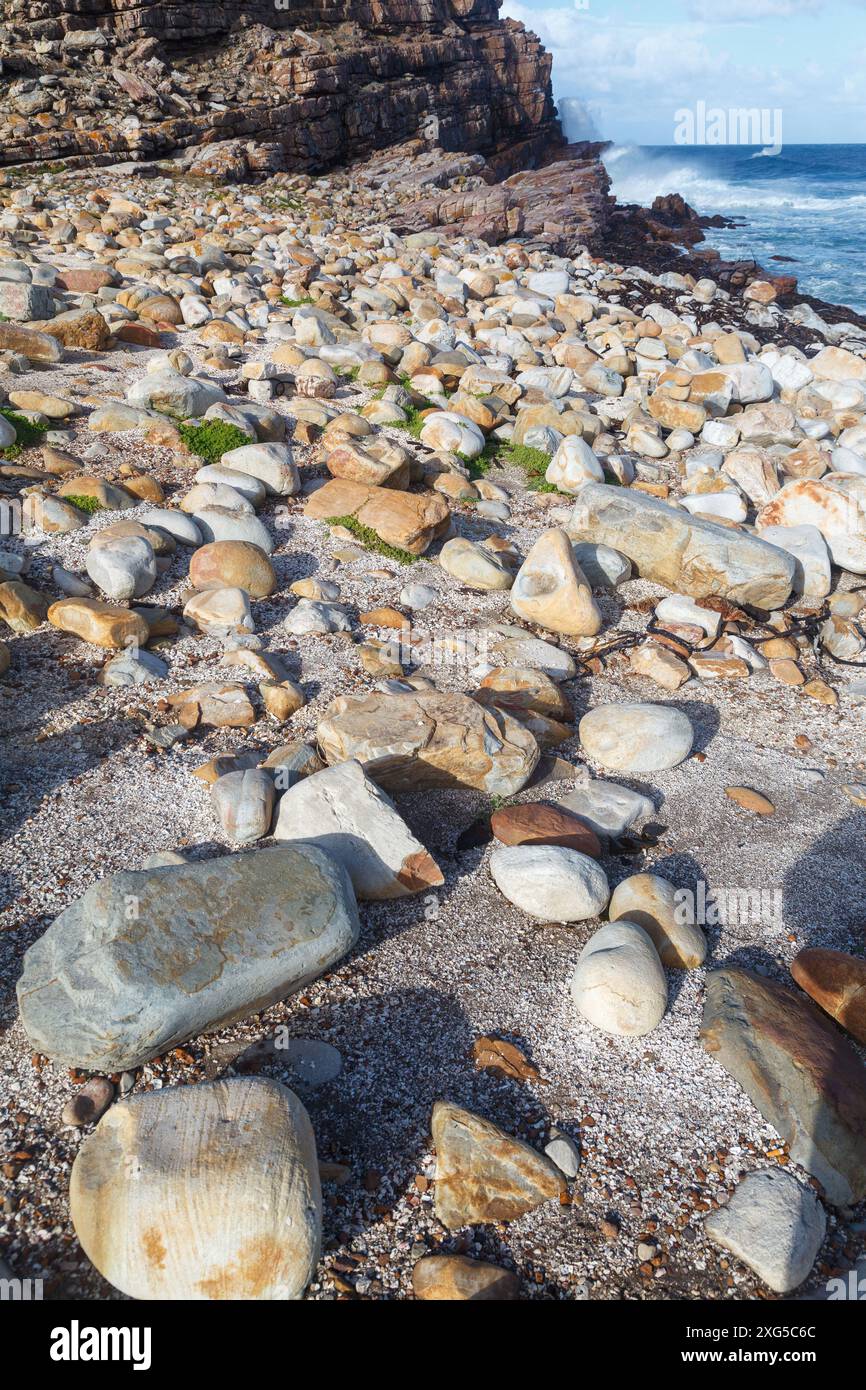 The waves hitting the rocks and orange rocks on the beach in Cape of ...