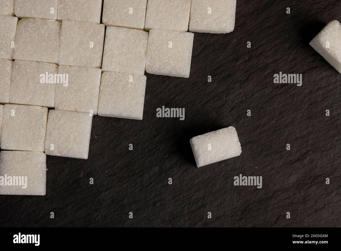 white square sugar on a black background , lump sugar in the shape of a ...