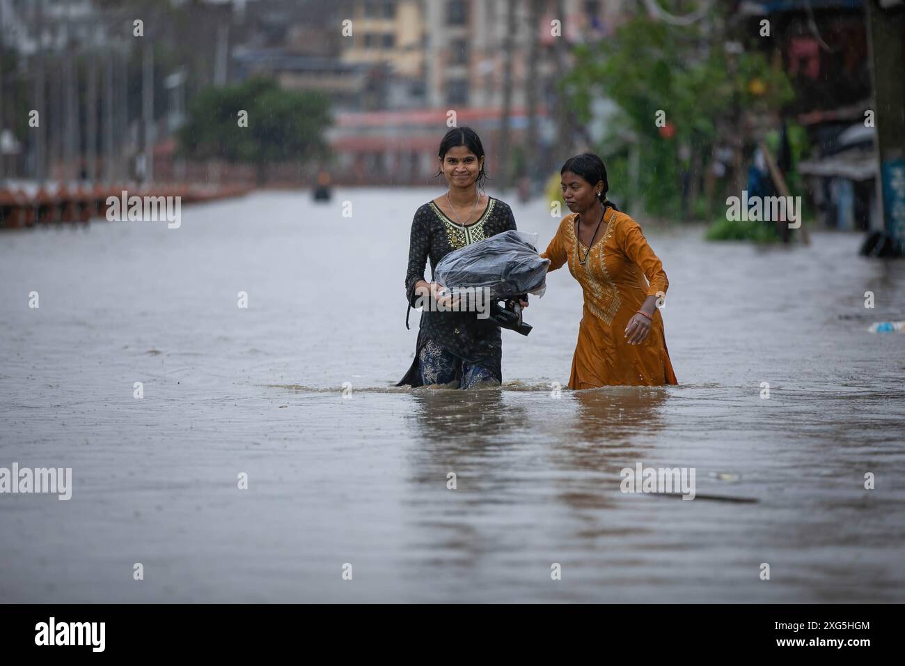 Kathmandu, Nepal. 06th July, 2024. Nepalese girls walk along a flooded street as a river
