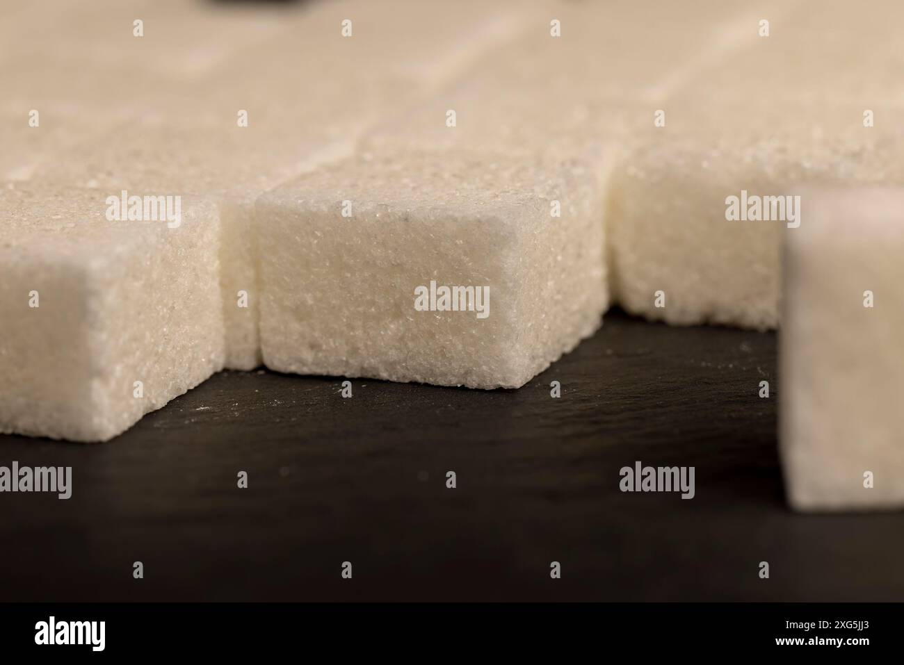 white square sugar on a black background , lump sugar in the shape of a ...