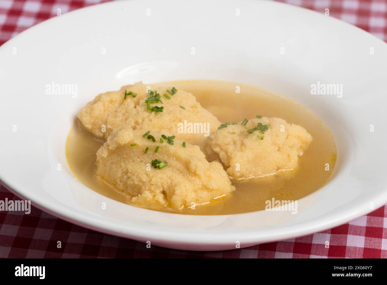 Bavarian dumpling soup on tablecloth Stock Photo
