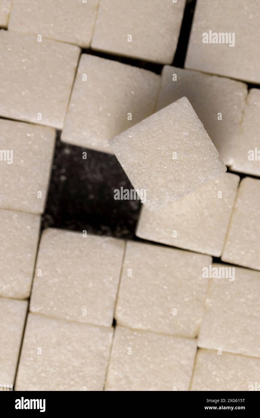 white square sugar on a black background , lump sugar in the shape of a ...
