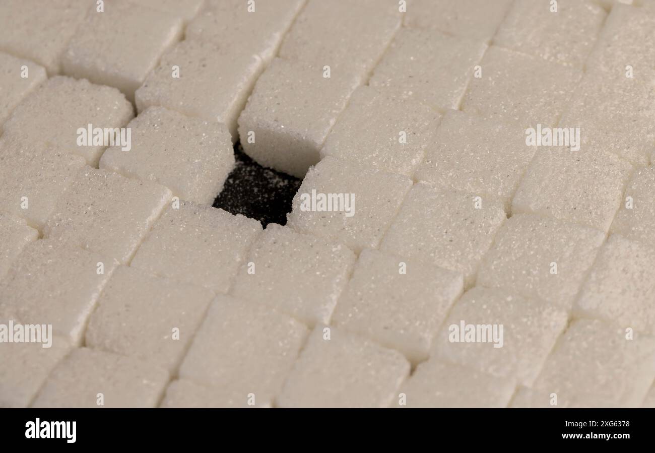 white square sugar on a black background , lump sugar in the shape of a ...