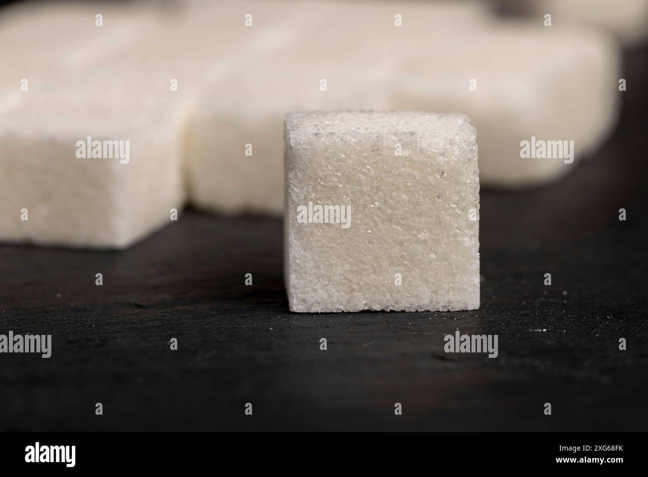 white square sugar on a black background , lump sugar in the shape of a ...