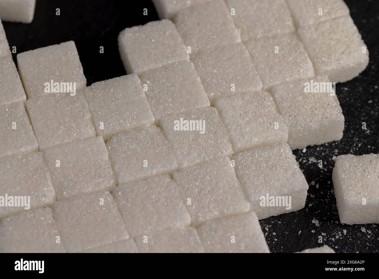 white square sugar on a black background , lump sugar in the shape of a ...