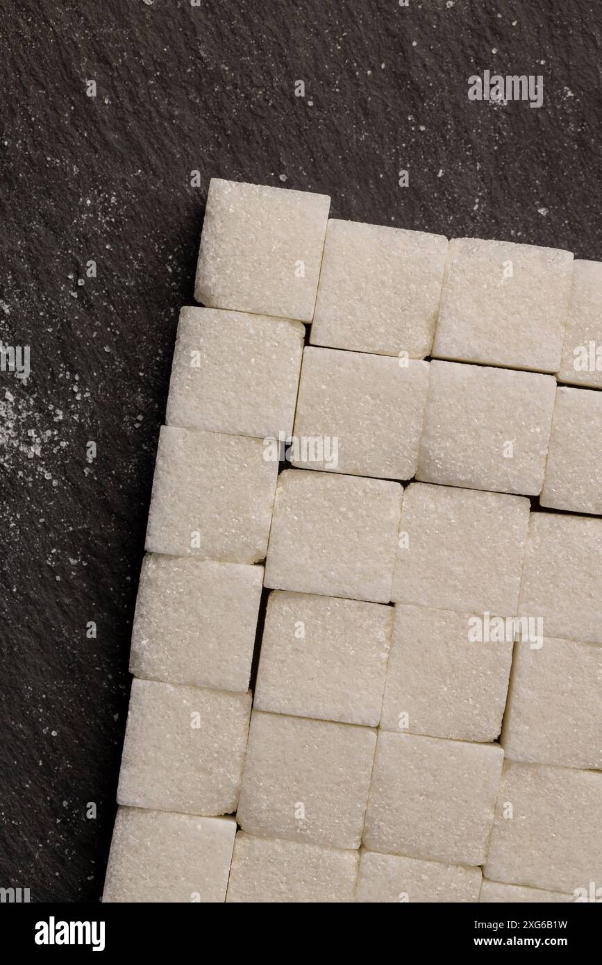 white square sugar on a black background , lump sugar in the shape of a ...