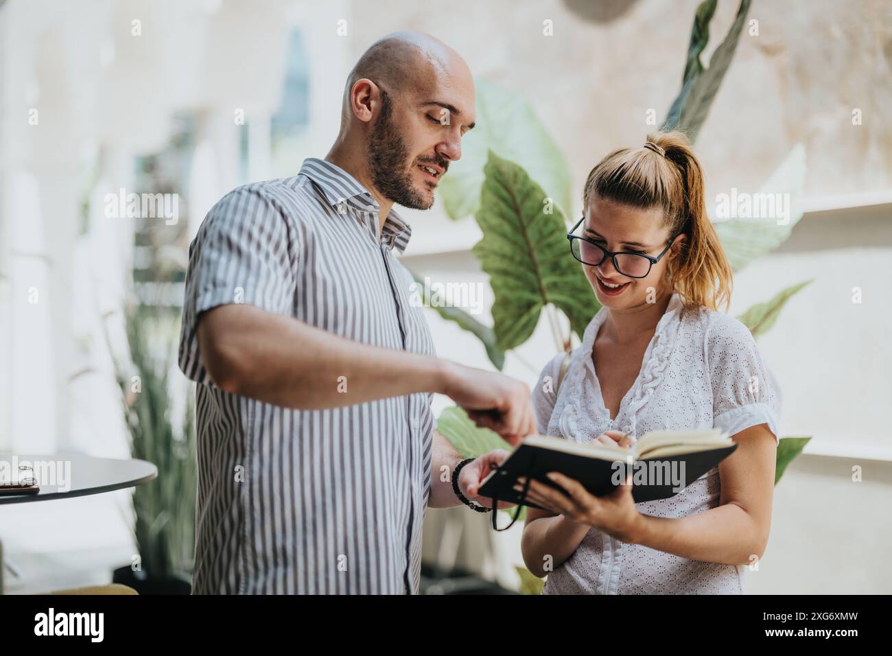 Collaborative brainstorming session between colleagues in a modern, bright office setting Stock Photo