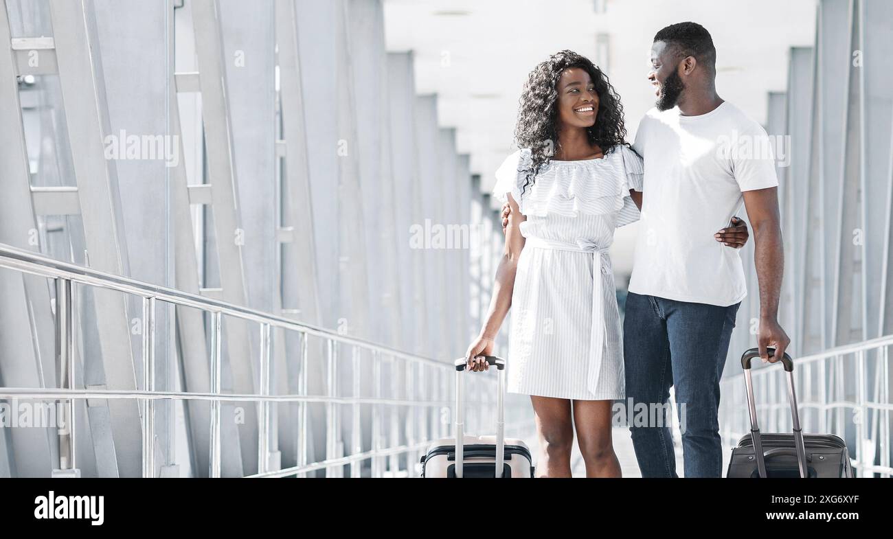 Happy Black Couple Walking Through Airport Terminal With Luggage Stock ...