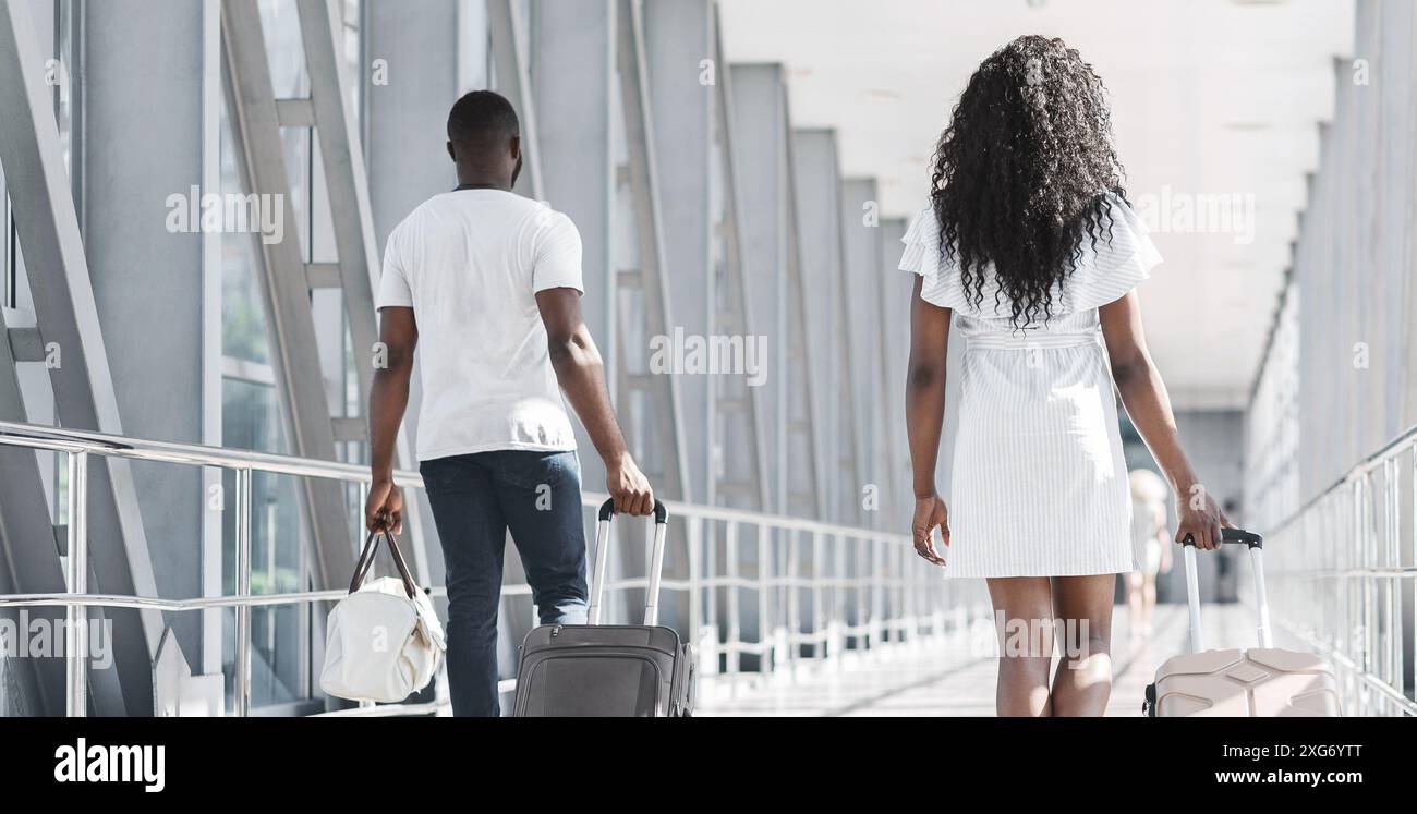 Couple Walking Through Airport Concourse With Luggage, Back View Stock ...