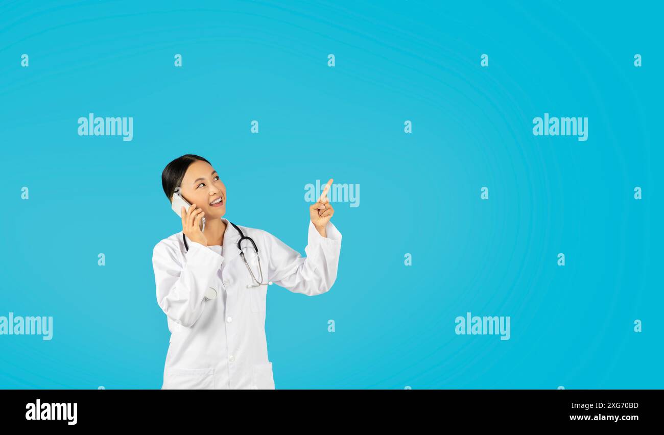 Asian woman pointing upwards hi-res stock photography and images - Alamy