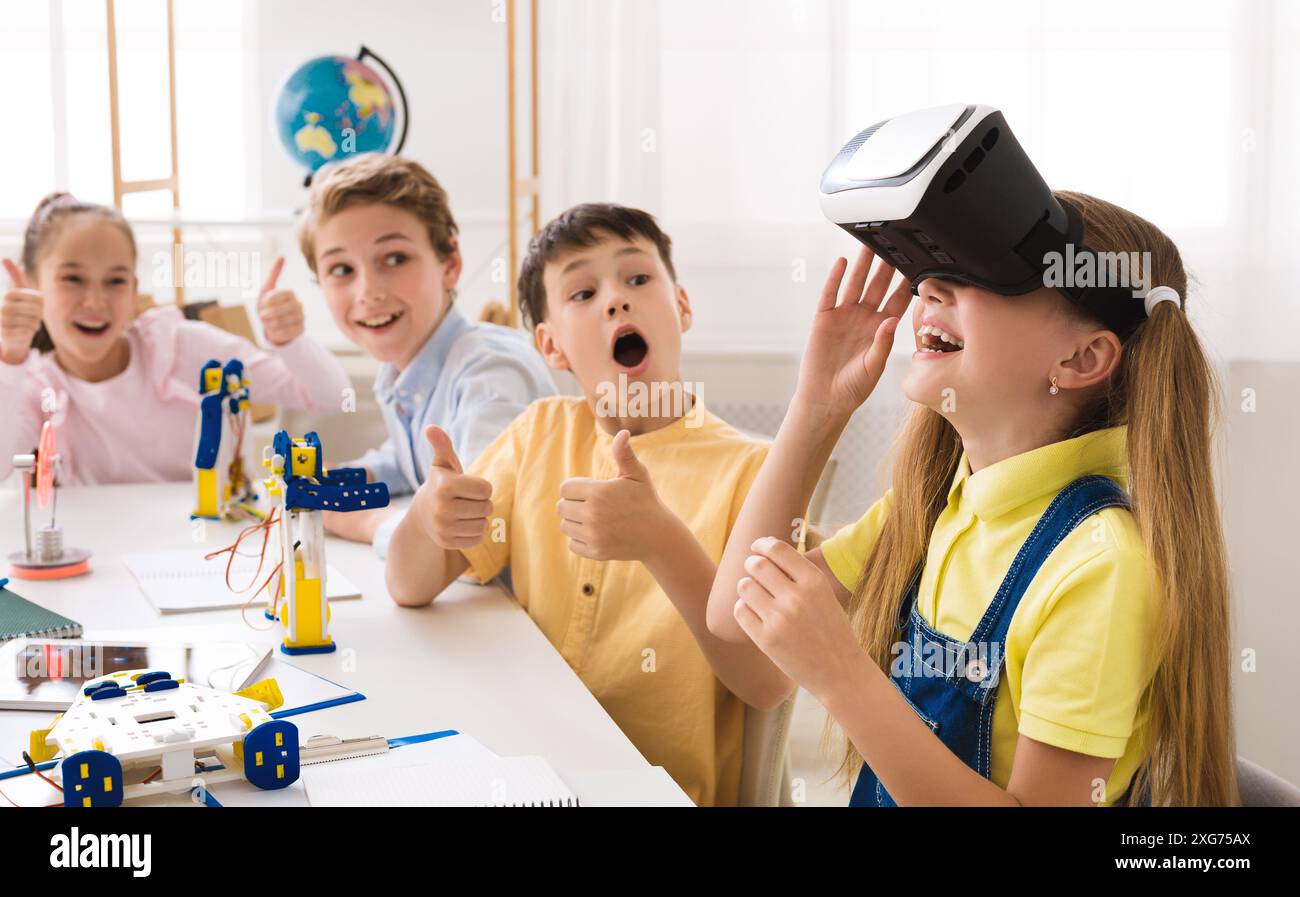 Excited Elementary School Students Explore Virtual Reality During STEM Class Stock Photo