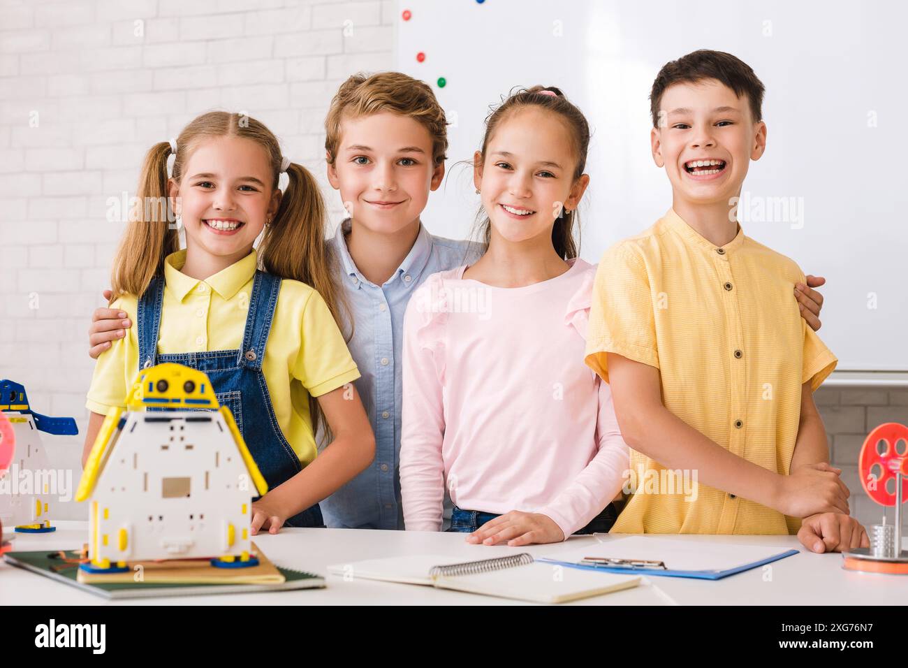 Smiling Students Working On Robotics Project In Classroom Stock Photo