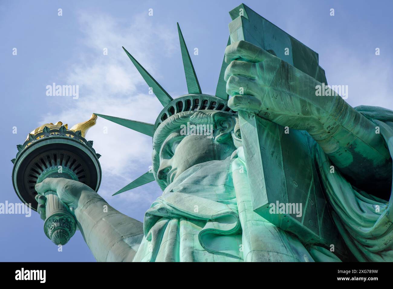 The iconic Statue of Liberty on Liberty Island. The copper clad statue is a figure of Libertas, the Roman goddess of liberty, holding a torch above he Stock Photo