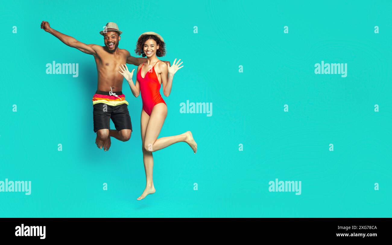 Playful energetic african american couple jumping on blue Stock Photo