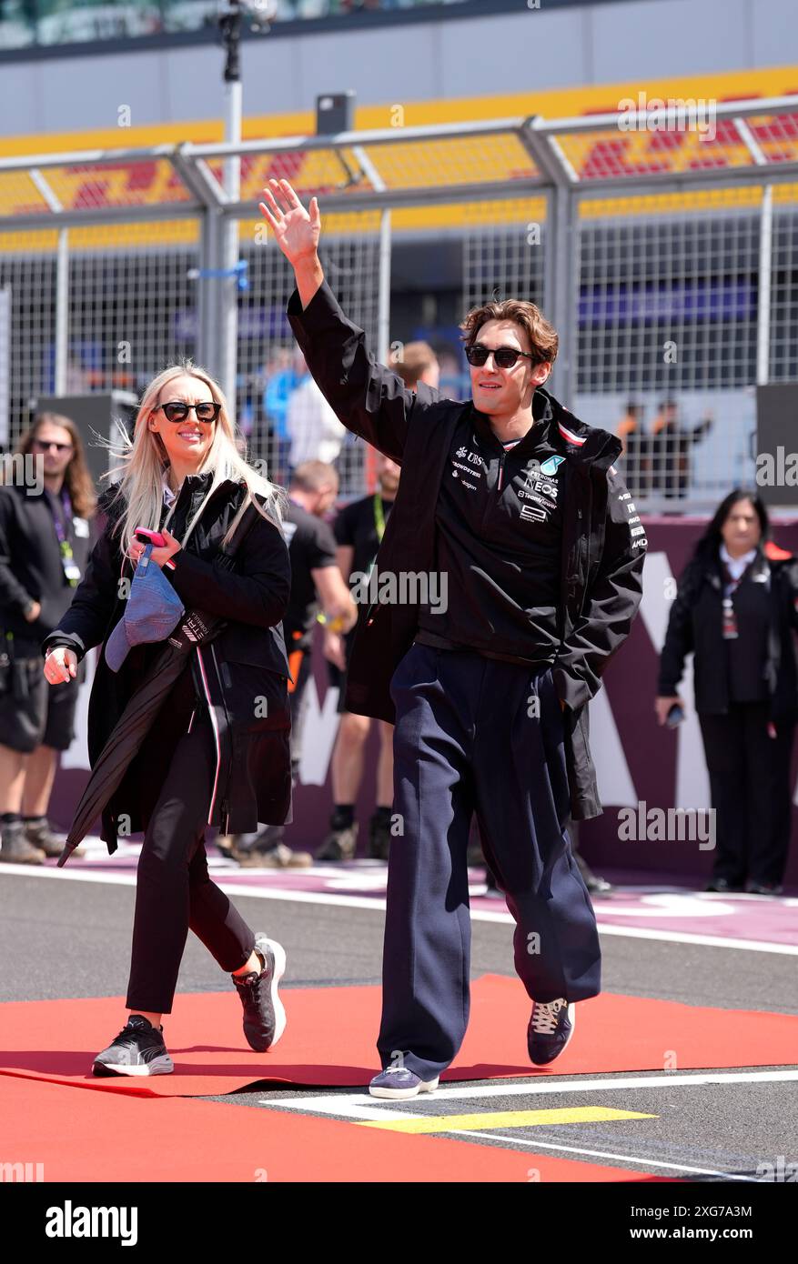 Mercedes driver George Russell waves to fans as he arrives at the track ...