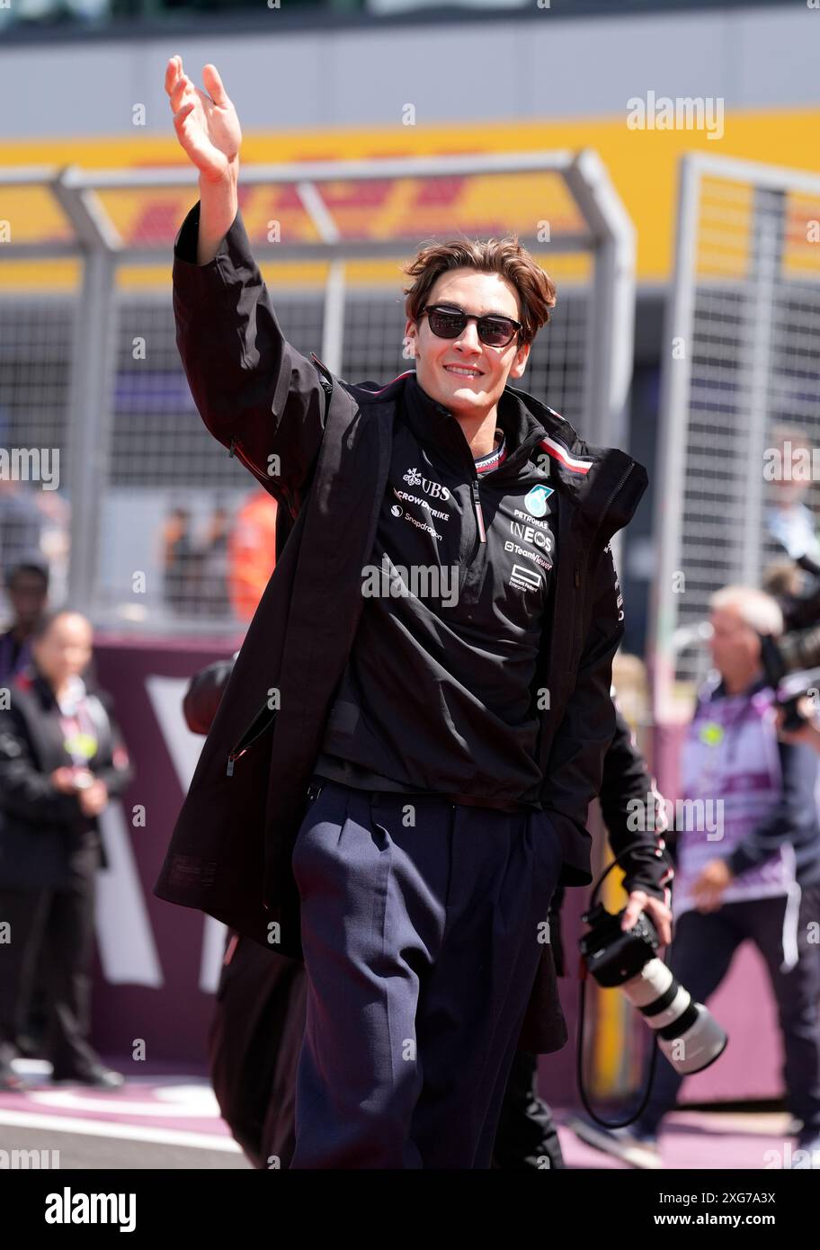 Mercedes driver George Russell waves to fans as he arrives at the track ...