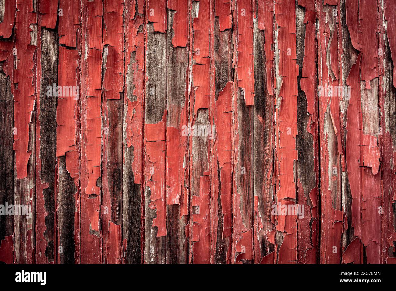 Old red paint peeling off the wooden panels Stock Photo
