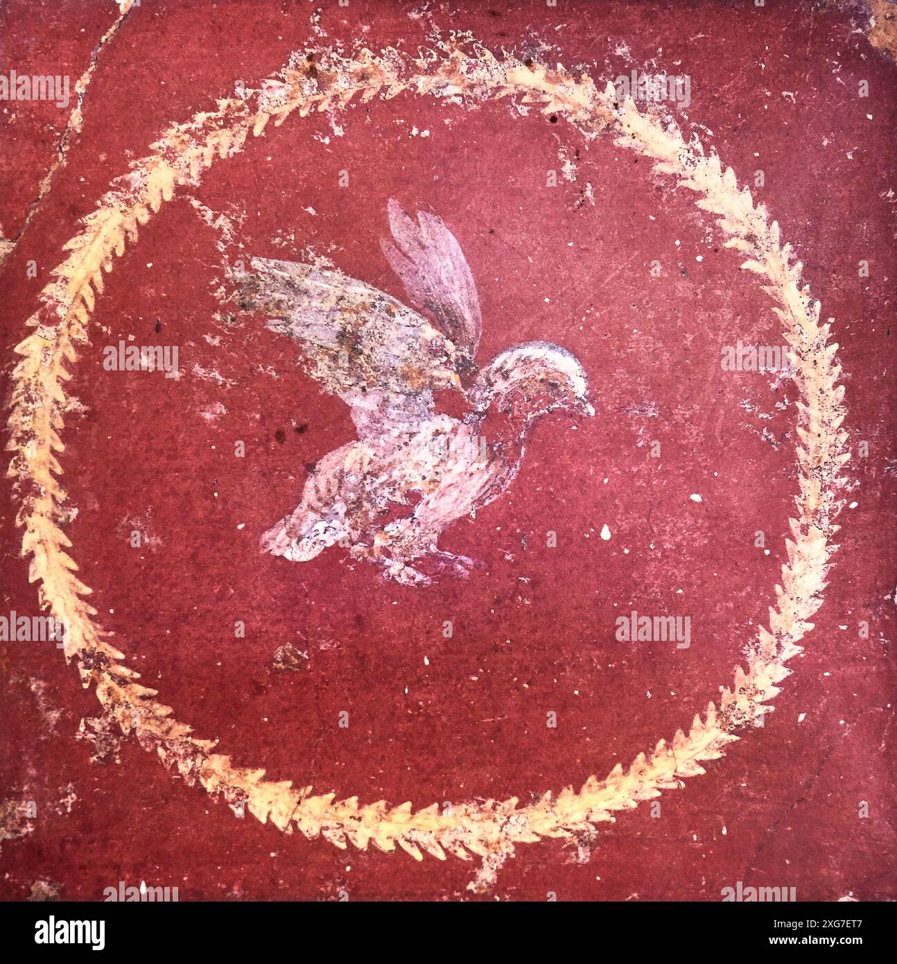 stylized figure of a bird on a red background, ancient Roman fresco in a domus of Pompeii. Pompeii UNESCO heritage site, destroyed by the eruption of Stock Photo