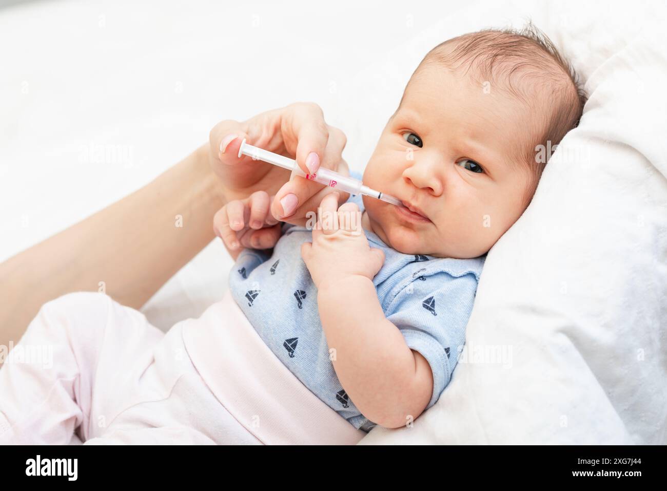 Mother feeding newborn baby with Vitamin K to prevent Vitamin K