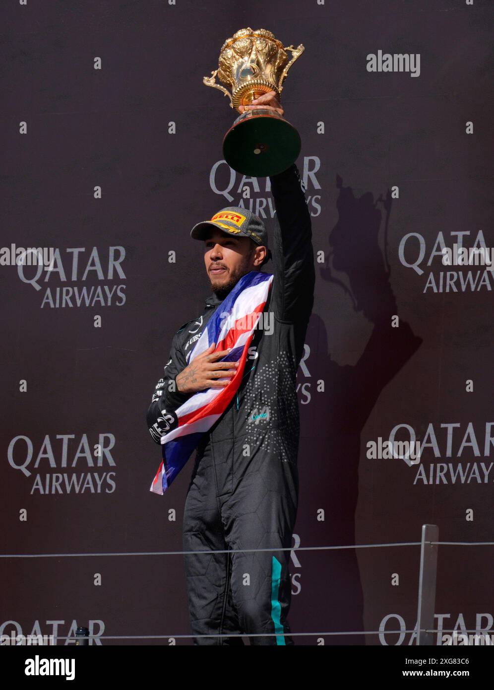 Mercedes driver Lewis Hamilton lifts the British Grand Prix Trophy as ...