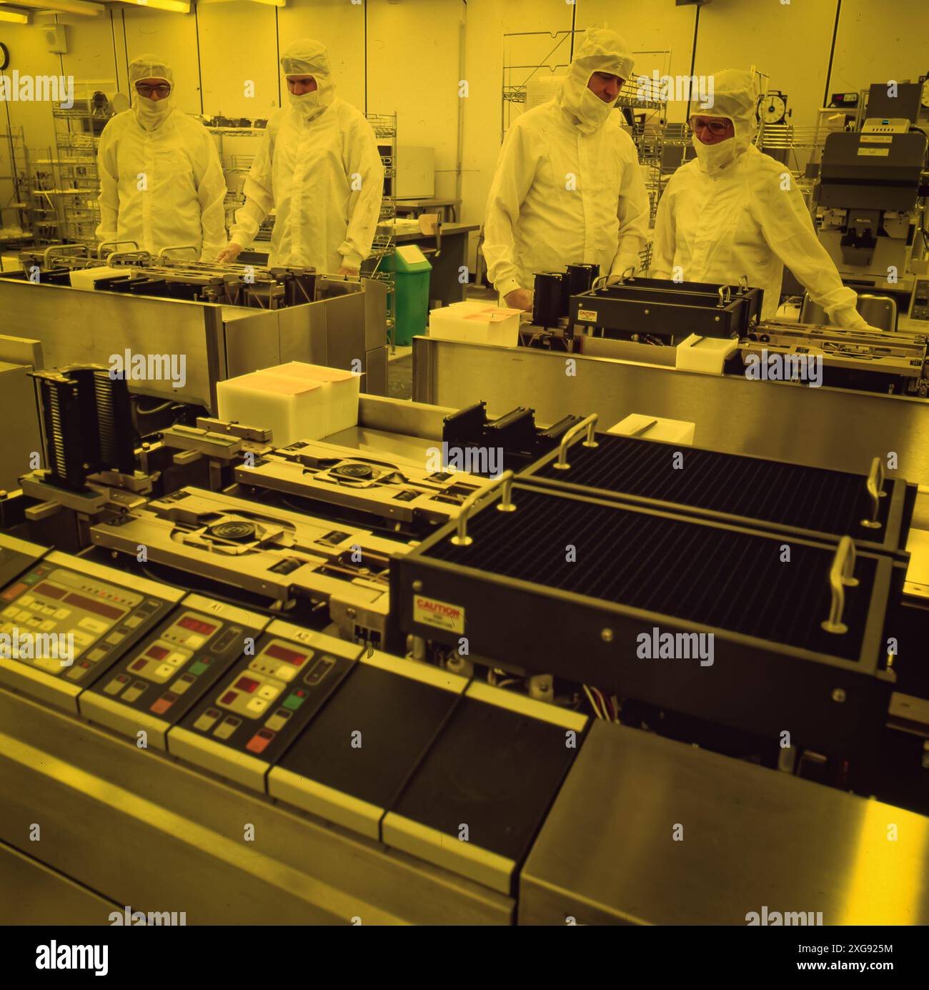 Technicians in full cleanroom suits inspect semiconductor manufacturing ...