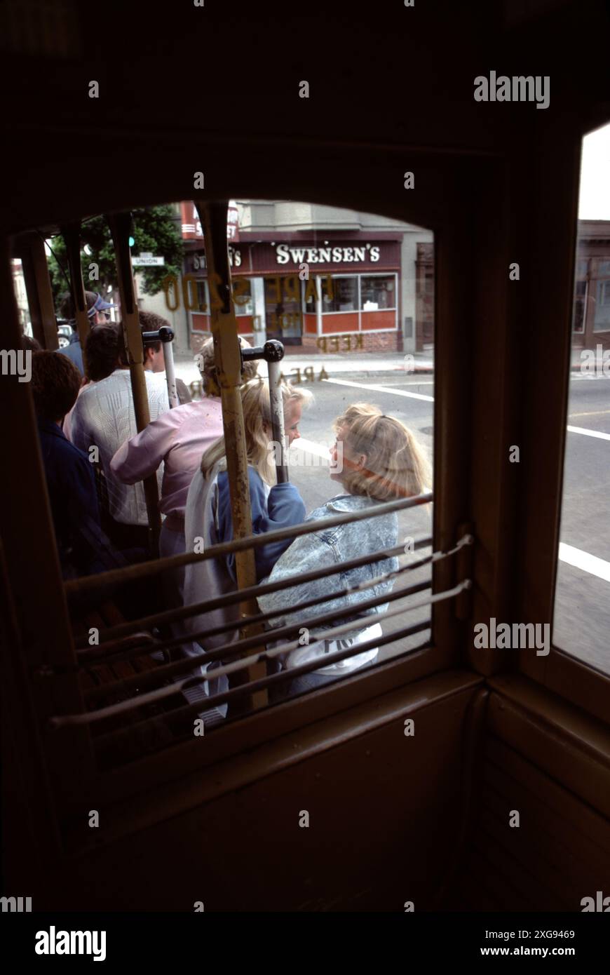 San Francisco CA., USA., Summer 1995. Riding San Francisco’s historical cable cars to Fisherman’s Wharf.  Young folks riding the Fisherman’s Wharf bound cable car.  9.7 million people ride cable cars each year.  Building a cable car is an exacting art that takes several dozen craftsmen 18 to 24 months to complete. Streetcars are different from cable cars. World War II opened up cable car jobs for African-Americans and women. Muni holds a cable car ringing competition every year.  The cable cars are the world's last manually operated cable car system. Stock Photo