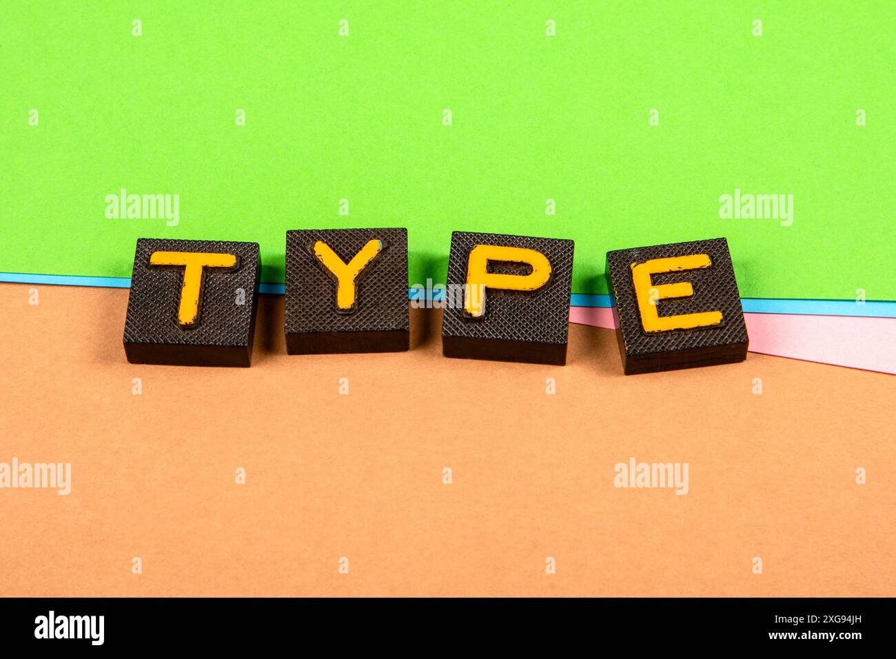 TYPE. Old letter tiles on a colored paper background. Stock Photo