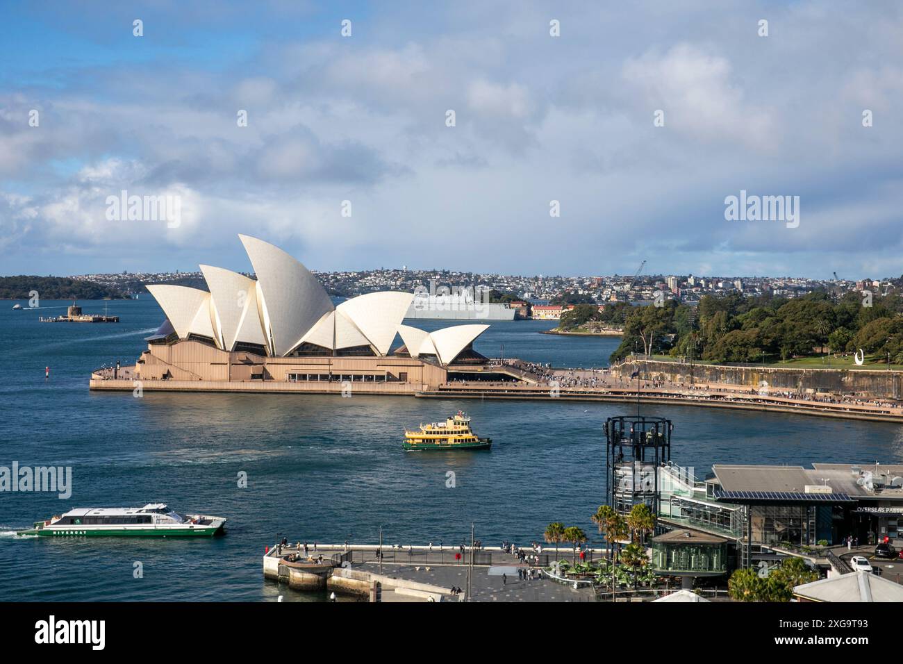 Sydney Opera House and harbour view with Sydney ferry on the harbour and HMAS Canberra at Garden Island naval base, New South Wales,Australia Stock Photo