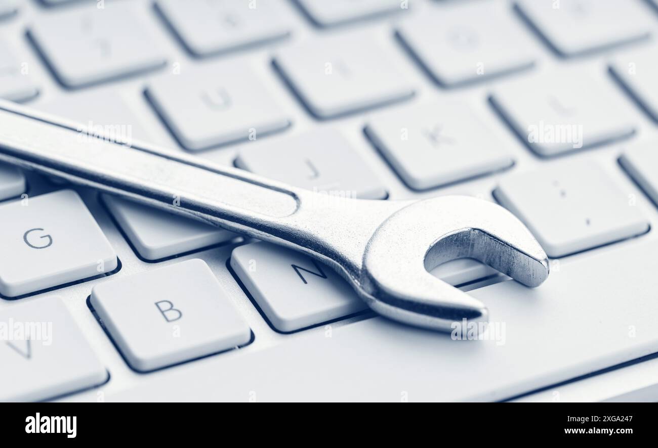 Computer fixing, service or maintenance concept background. Wrench on computer keyboard. Close up Stock Photo