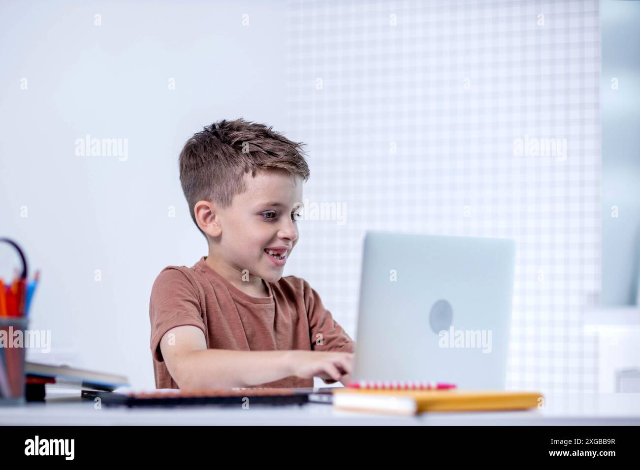 Distance learning online education. A schoolboy is studying at home using a laptop. Home distance learning. Stock Photo
