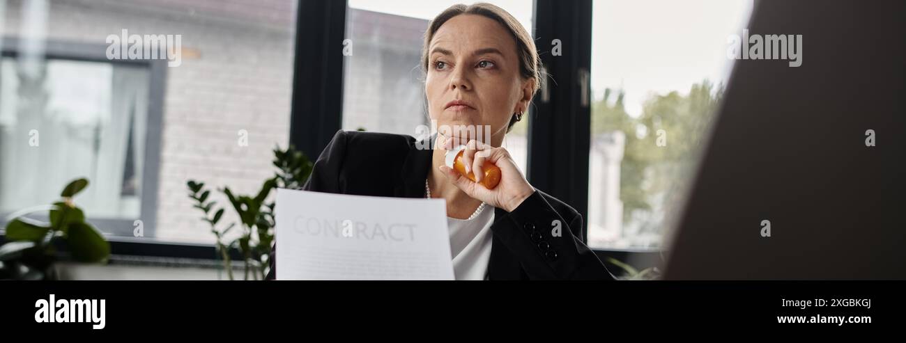 Woman sitting at window, reading paper with intense focus. Stock Photo