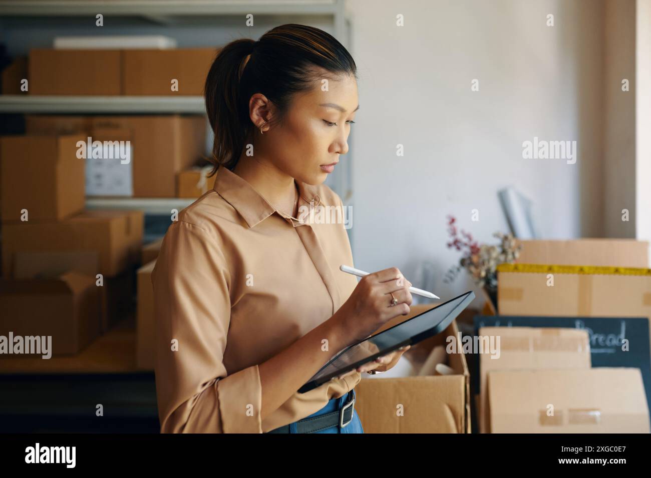 Woman Using Tablet PC In Warehouse Stock Photo