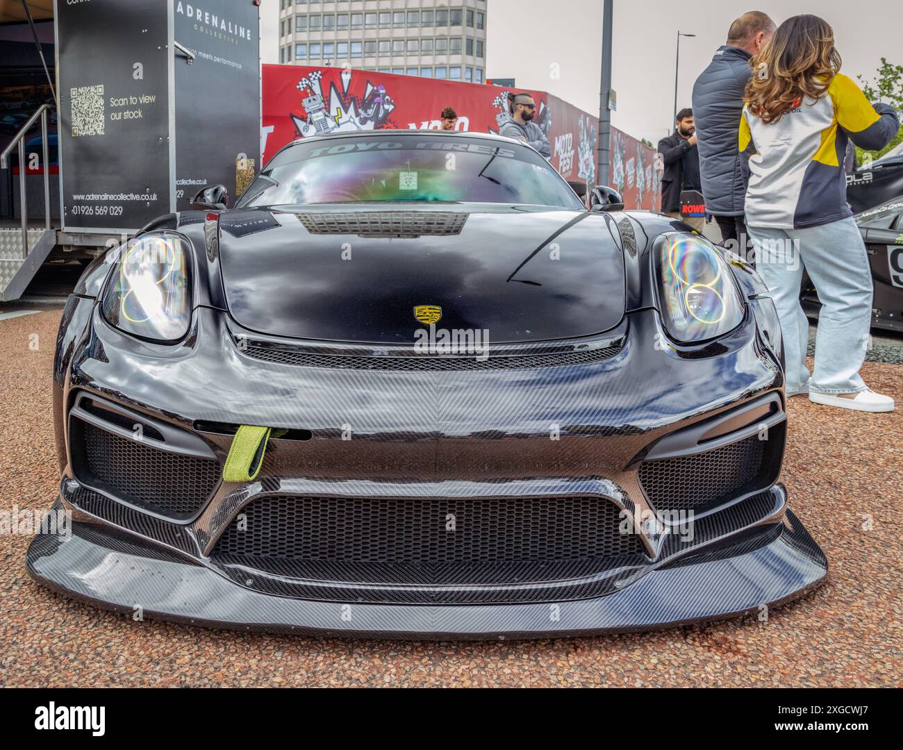 Front view of a Porsche Cayman fitted with a body styling kit parked in an urban setting during Coventry Motofest. Stock Photo