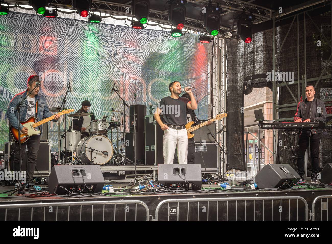 A pop band playing on a stage during Coventry Motofest. Musicians performing on stage. A music group playing a concert on stage. Stock Photo