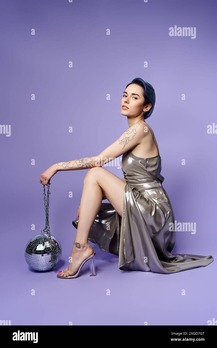 A young woman with short blue hair posing elegantly in a silver party dress  Stock Photo - Alamy