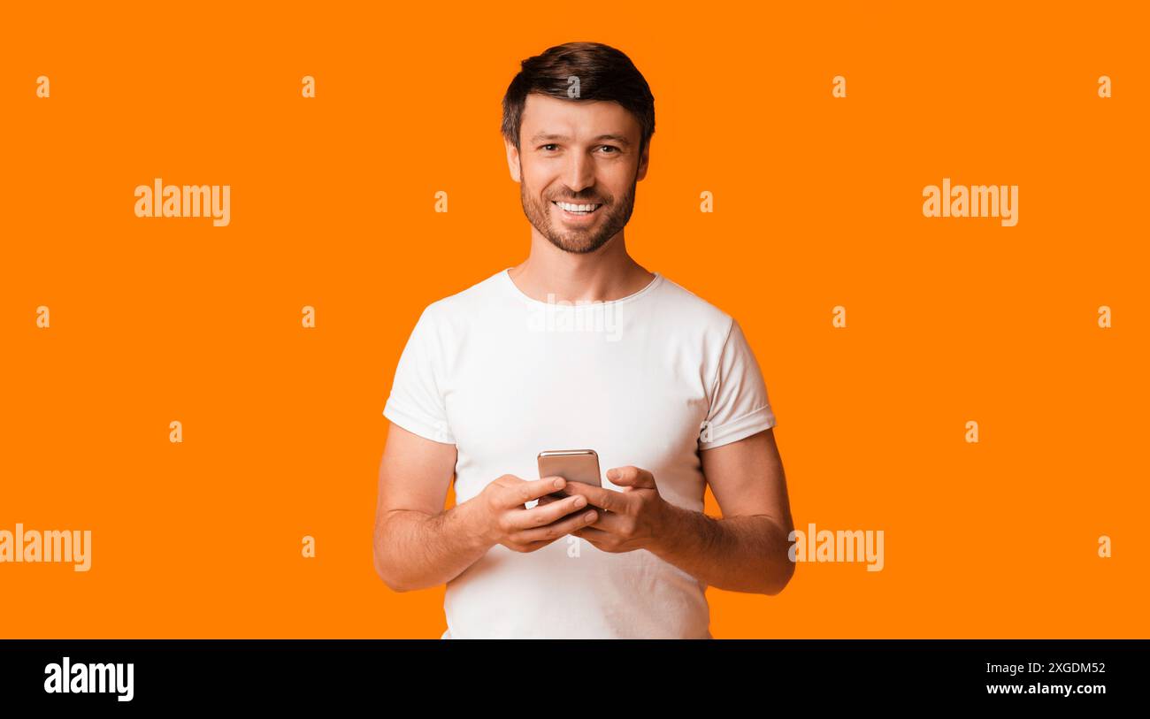 Smiling Man Using Smartphone, Studio Shot, Panorama Stock Photo