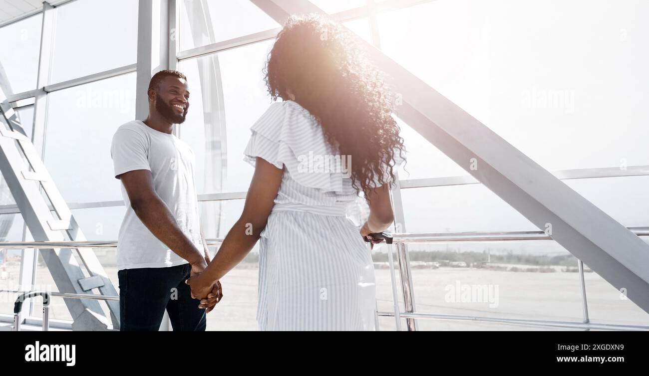 African American Loving Couple Holding Hands In Airport Terminal Stock ...