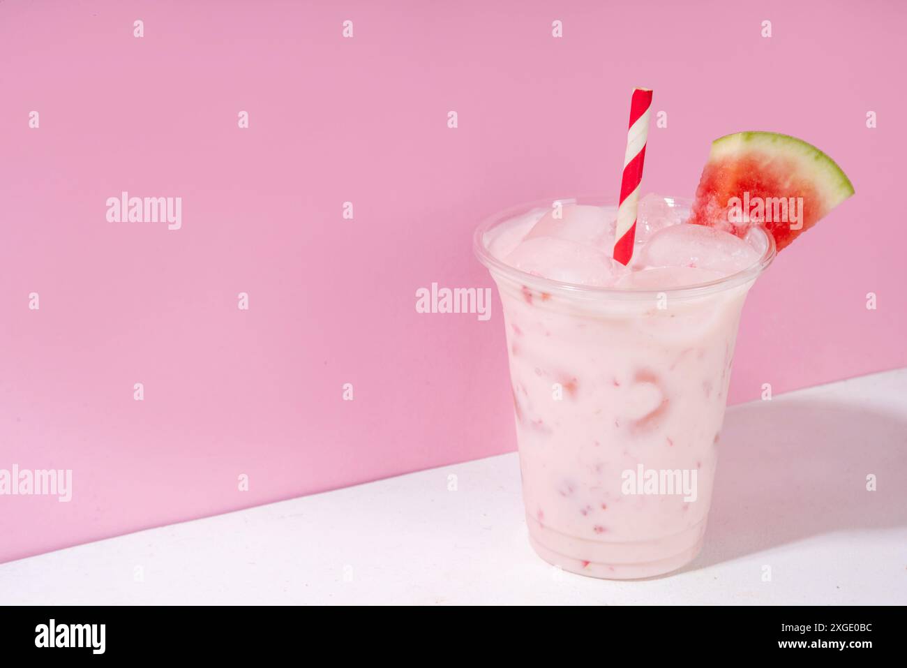 Tasty sweet watermelon milkshake or creamy slushie cocktail, garnished with watermelon slice in plastic cup, copy space Stock Photo