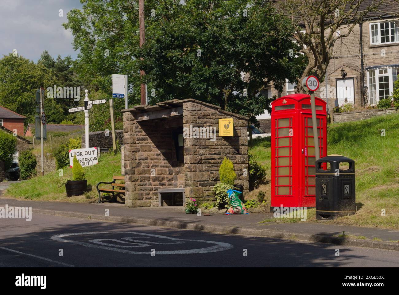 Red phone box and stone bus shelter Rainow village, Cheshire. Stock Photo