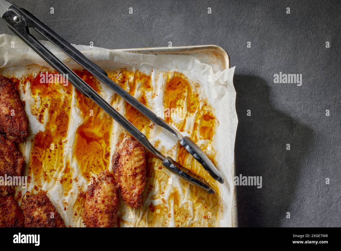 closeup of baked crispy spicy chicken wings on oven tray, top view, process of making crispy chicken wings Stock Photo