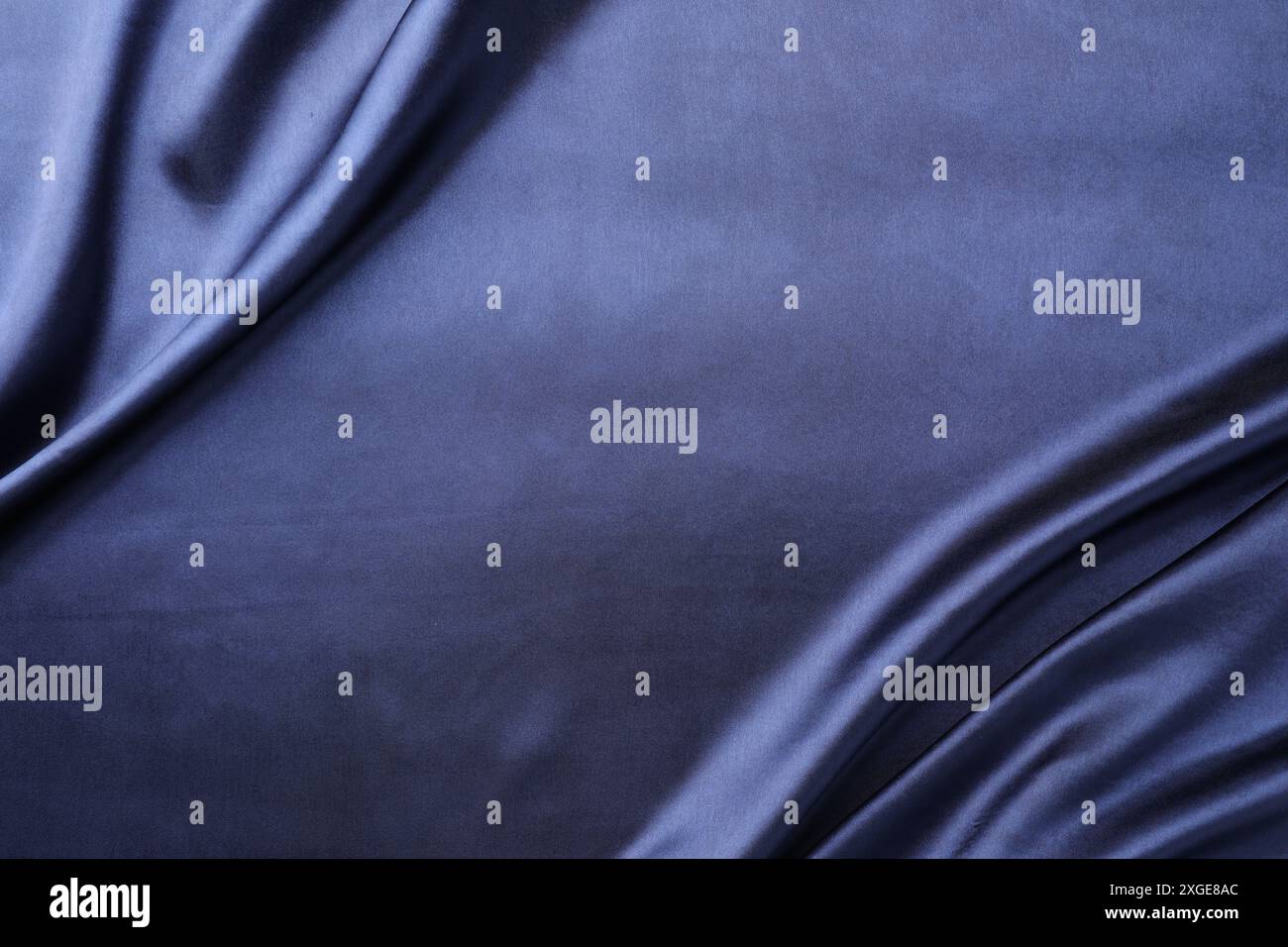 Crumpled dark blue silk fabric as background, top view. Space for text ...