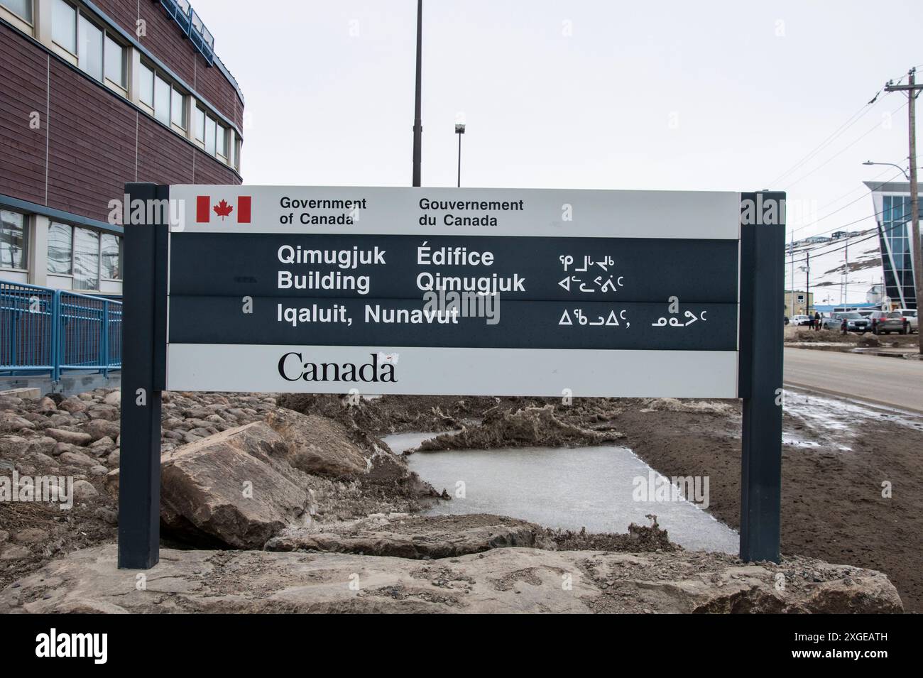 Multilingual Qimugjuk federal government building sign in English, French and Inuktitut on Federal Road in Iqaluit, Nunavut, Canada Stock Photo