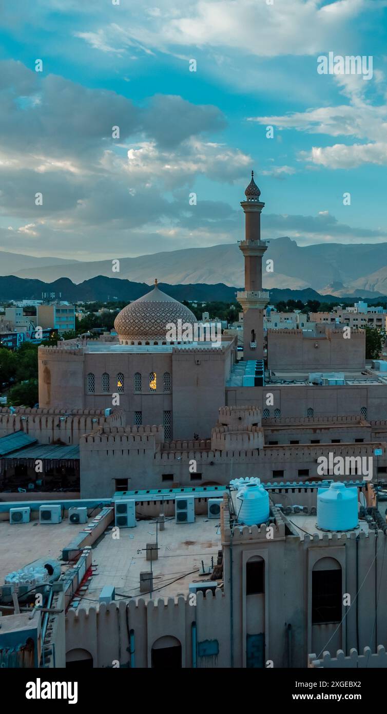 Beautiful sunset view of the old city of Nizwa, Oman with historic ruins and buildings including Nizwa Fort Stock Photo