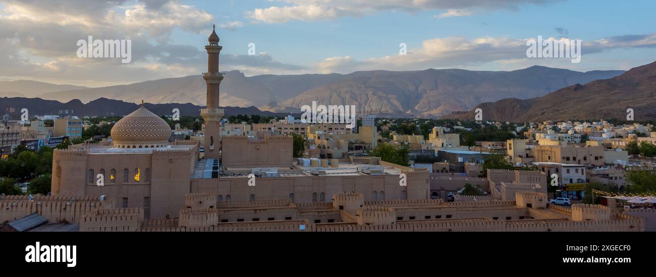 Beautiful sunset view of the old city of Nizwa, Oman with historic ruins and buildings including Nizwa Fort Stock Photo