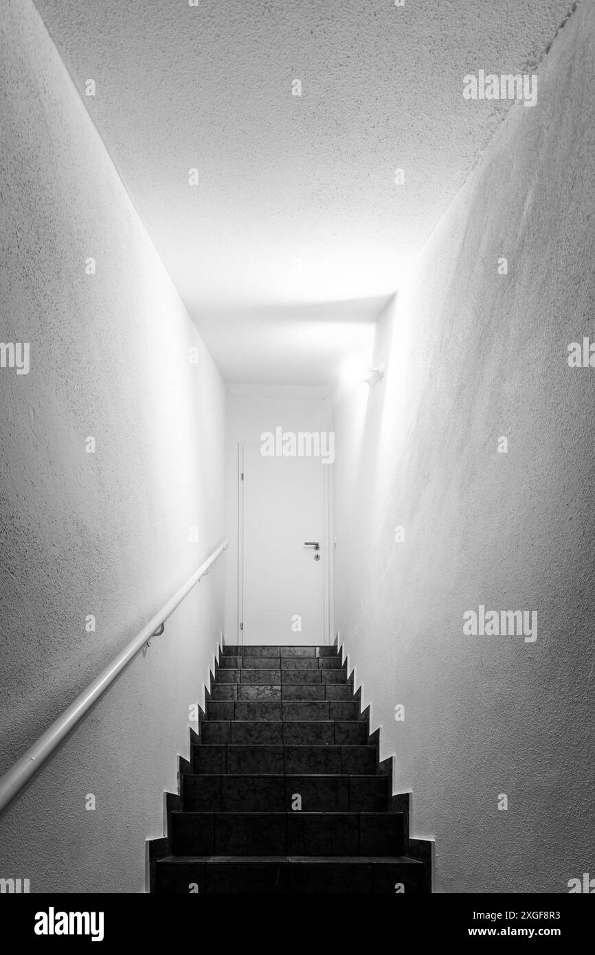 Basement stairs with balustrade, closed white door Stock Photo - Alamy