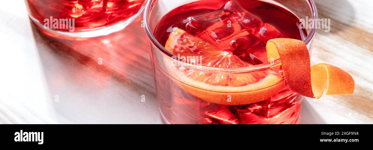 Negroni cocktail with orange peel, a panorama on a wooden background Stock Photo