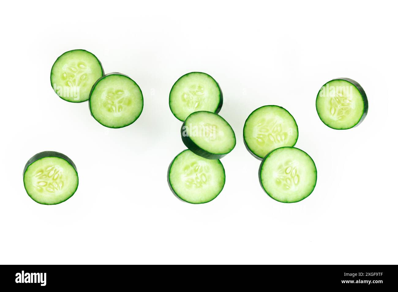 Cucumber slices, levitating on a white background, healthy food concept Stock Photo