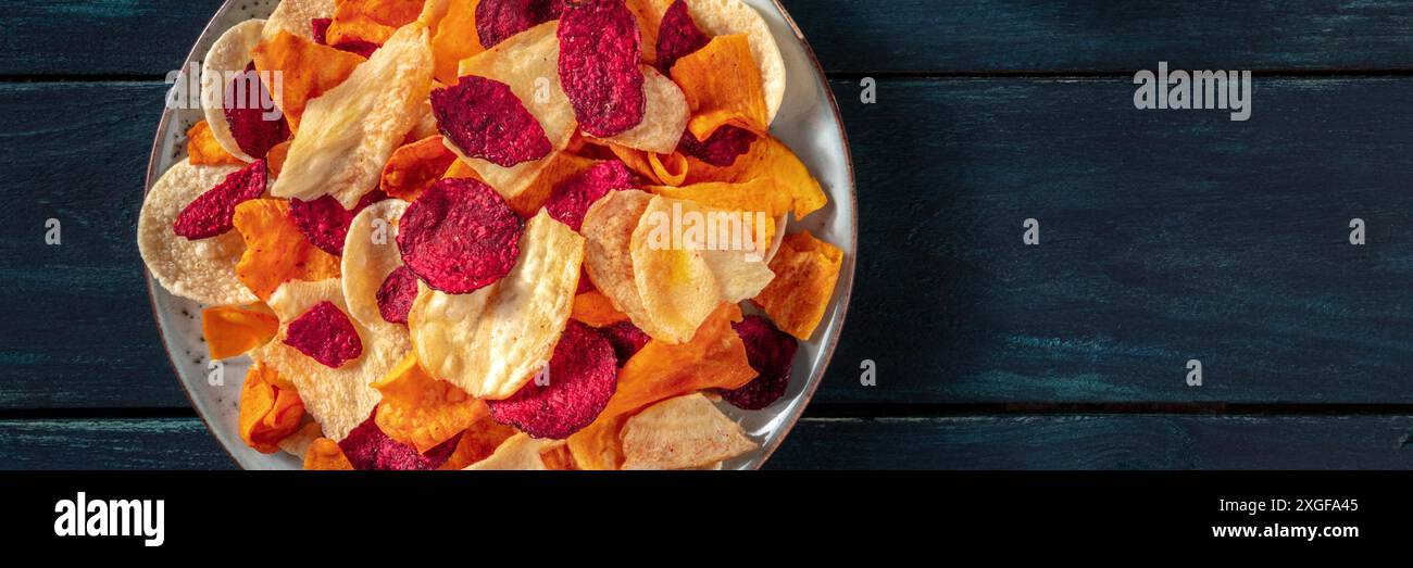 Vegetable chips panorama with copy space. Beetroot, sweet potato and other crisps, a healthy vegan snack Stock Photo