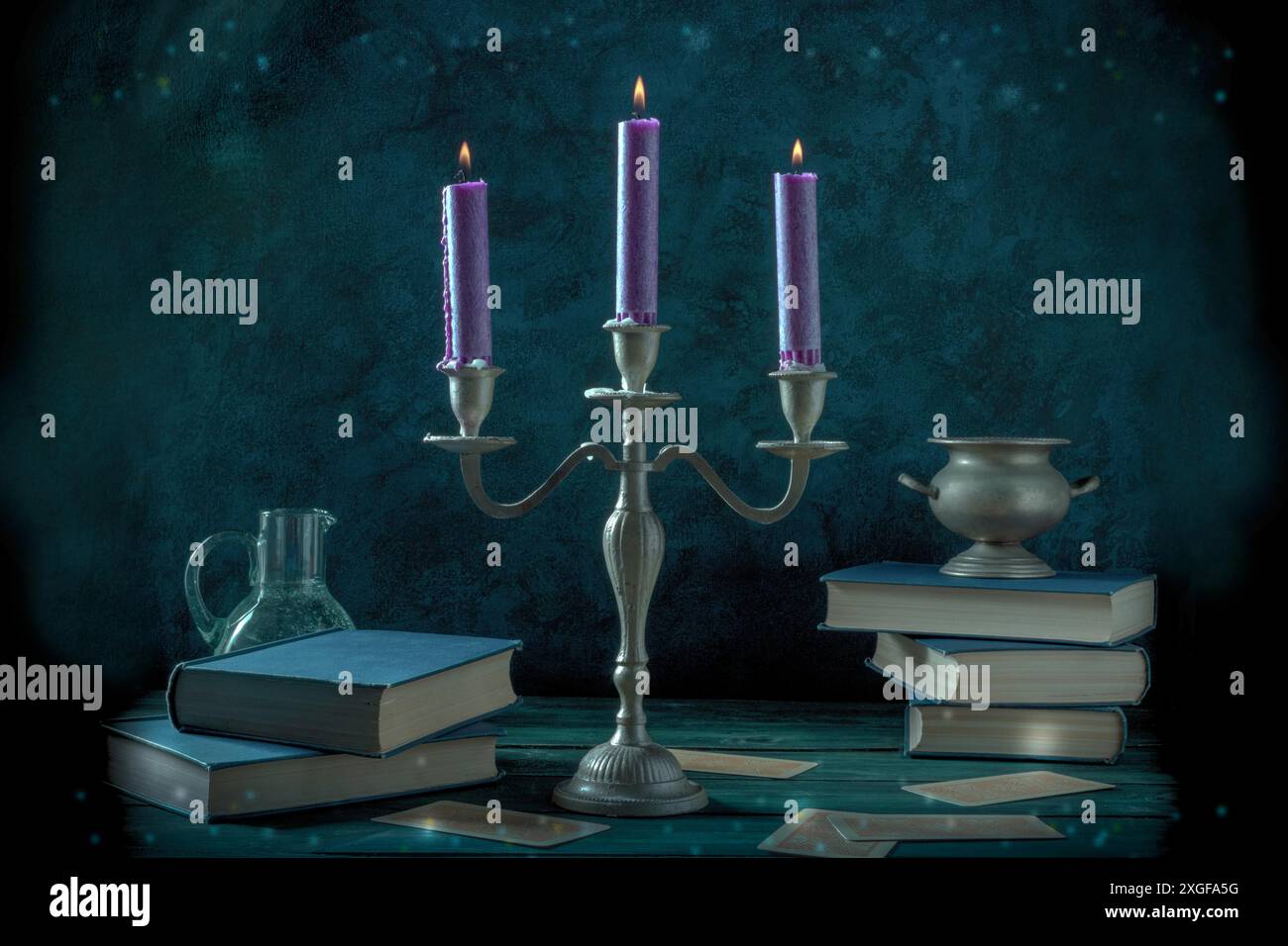 Candle magic. A witch's study with old books, magick potions, and divination cards, toned image Stock Photo